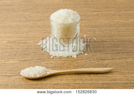 Japanese Cuisine Raw and Uncooked Japanese Rice in A Wooden Spoon and Glass Cup.