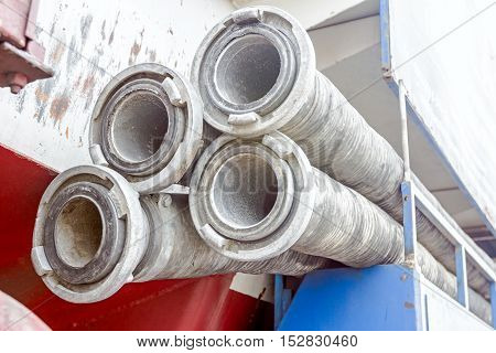 Water hose with couplings piled on the sewage truck suction or discharge hose.