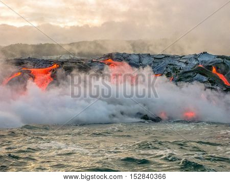 Scenic view from boat of Kilauea Volcano in Hawaii Volcanoes National Park, while erupting lava into Pacific Ocean, Big Island, Hawaii, United States.