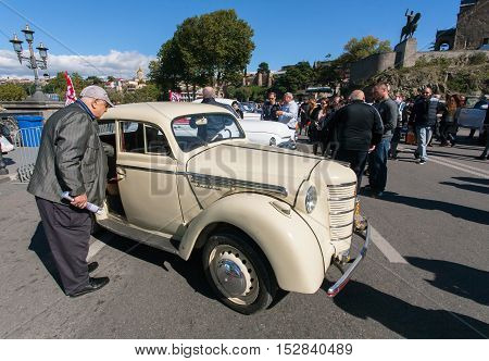 TBILISI, GEORGIA - OCT 16б 2016: Elderly man watching retro car on exhibition of vintage auto during the Tbilisoba on October 16б 2016. Tbilisoba is traditional festival in Tbilisi from 1979