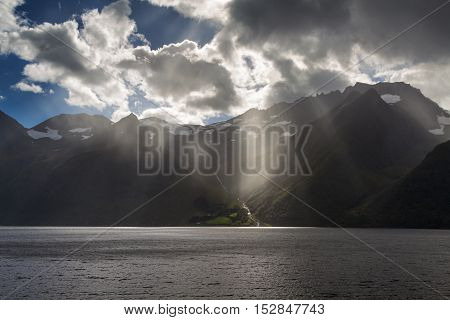 Sun beams at dramatic Hjorundfjord, Fjordland, Norway