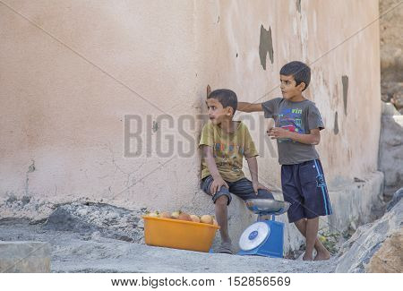 Wakan village Oman October 15th 2016: omani boys selling pomegranate fuits