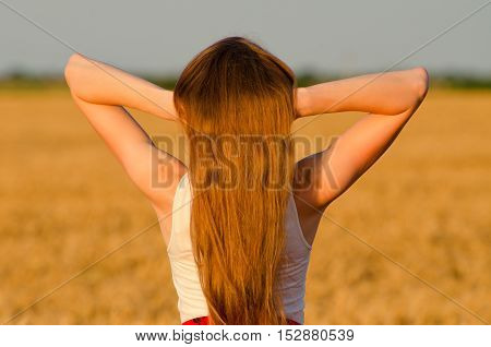 Girl holds hands on a nape long blond hair view from the back