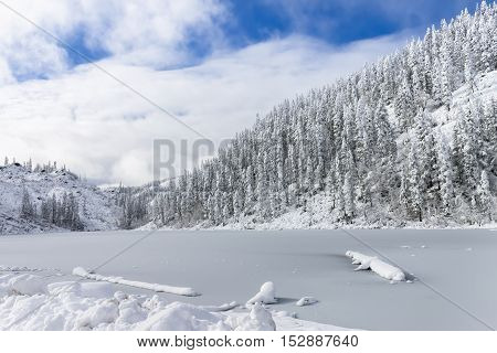 Beautiful lake Amut in taiga hills on Far East of Russia in early october. Mountain lake in winter. Beautiful nature. Snowy weather.