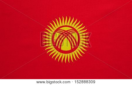 Kyrgyzstani national official flag. Patriotic symbol banner element background. Correct colors. Flag of Kyrgyzstan with real detailed fabric texture accurate size illustration