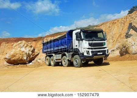 large dump truck driving in the dust in the quarry