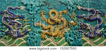 TILES OF DRAGON SCULPTURES ON THE WALL