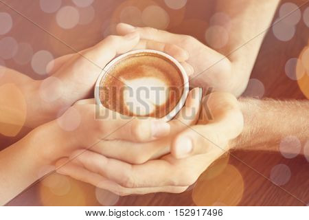 Young couple holding cup of coffee on table