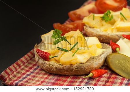 Two kinds of cheese on bread. Healthy breakfast on the kitchen table. Bread with cheese cherry tomato and chilli.