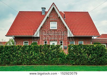 Two-storey House behind the Green Fence in Small City