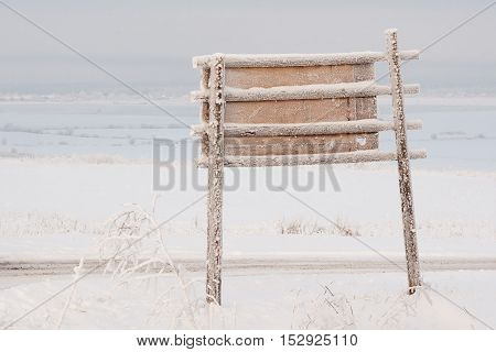 Frozen bigboard with copyspace against winter landscape
