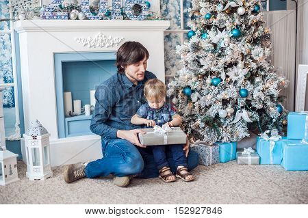 Father And Son At The Fireplace And Christmas Tree