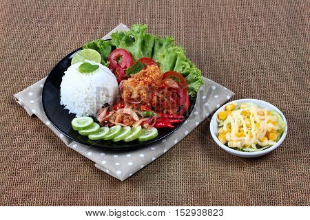 Jasmine rice with spicy fried chicken salad (Khao Yum Kai Zap in Thai) served mixed vegetables salad.