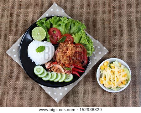 Jasmine rice with spicy fried chicken salad (Khao Yum Kai Zap in Thai) served mixed vegetables salad.
