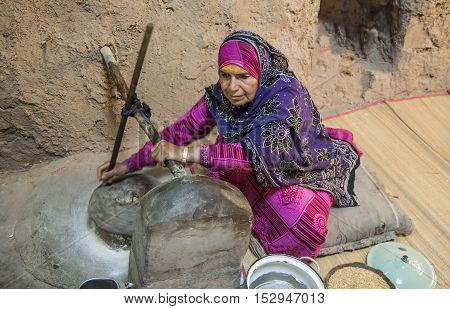 Nizwa Oman October 13th 2016: omani lady grinding wheat