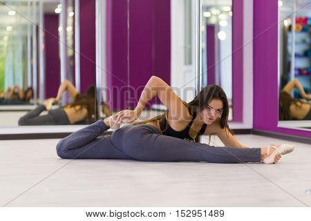 Pretty woman doing yoga in the studio