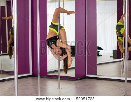 Beautiful pole dancer performing at the studio