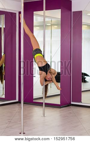 Beautiful pole dancer performing at the studio