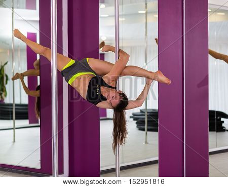 Beautiful pole dancer performing at the studio