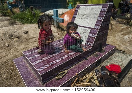 Chichicastenango Guatemala - April 24 2014: Children sitting in a grave in the cemetery of the town of Chichicastenango in Guatemala