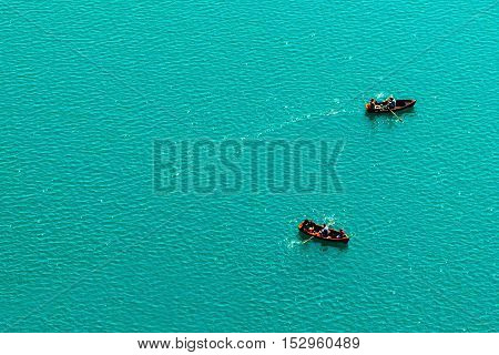 Rowing boats on lake enjoying summer and outdoor activities aerial view of unrecognizable people and freshwater surface as copy space
