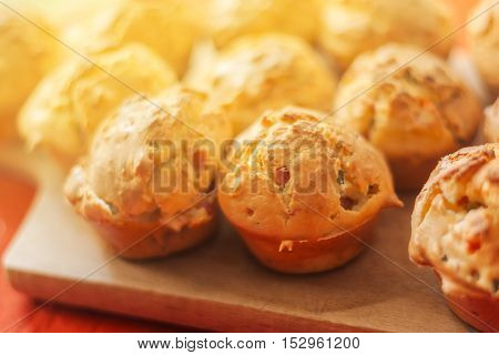 Tasty homemade salty cupcakes served on wooden plate selective focus