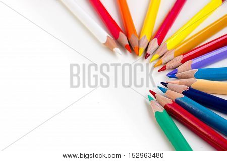 Colored pencils isolated on white background. Bright template with copyspace. Educational background.