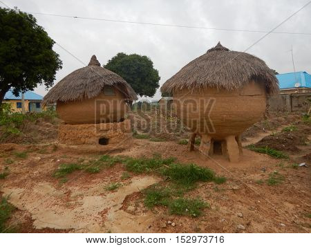 Native silos for rain and food storage in Erena,  Niger State Nigeria. They are usually made from mud with thatched roof. There are small windows to access the inside of the silos. It is usually elevated on stone arrangement. The one on the left has a mud