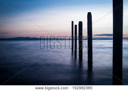 Night picture of Point Roberts pilings and silky water at night time