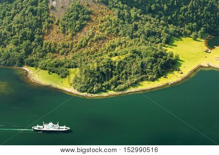 Pleasure boat ship are sailing between fjords. Amazing nature of the Norwegian mountains in Sognefjord. Nature of Norway. Travel concept. Scenic view from mountain top.