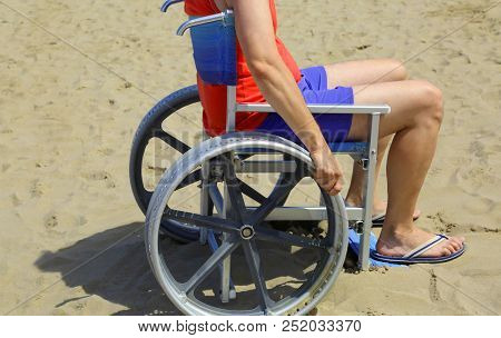 Man With Special Wheelchair On The Beach In Summer