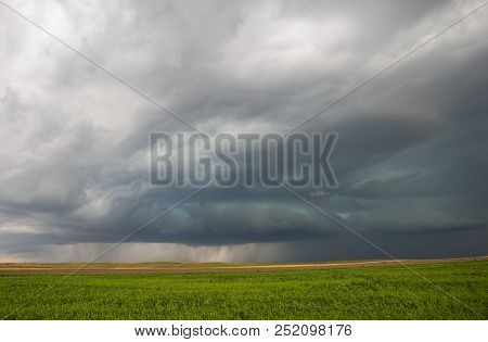 An Approaching Severe Storm Emits A Strange Green Glow In The Sky. Heavy Rain Is Seen Under The Clou