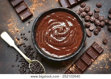 Chocolate Ganache In A Black Bowl With Ingredients For Making.top View.
