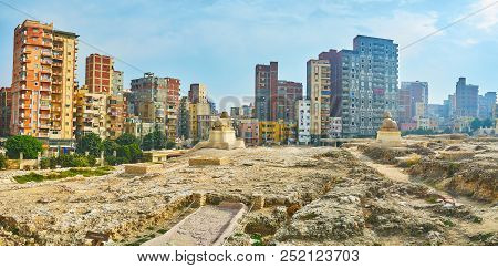 Panorama Of Serapeum Temple Ruins With Two Statues Of Sphinxes And Residential High-rises On The Dis