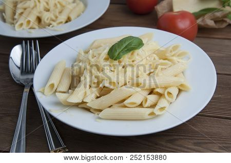 Cooked Penne Pasta With Butter And Cheese, Isolated In White Round Plate, Over Wooden Table, Decorat