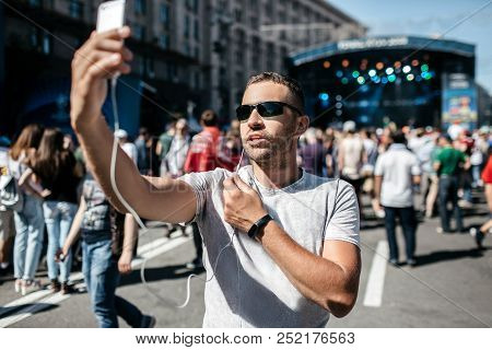 A Young Boy Is A Coverage Of A Sporting Event, Or A Concert. A Blogger Is Using A Smartphone To Go L