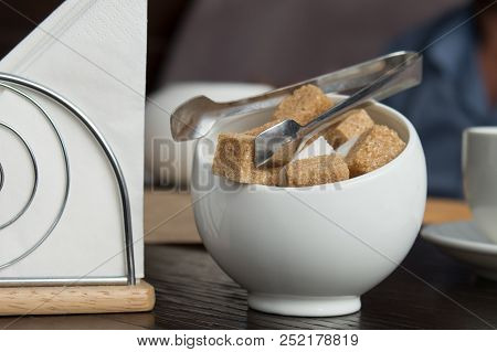 A Cup With Cubes Of White Cane Sugar, Sugar-tongs And Napkins. Atmosphere And Table Appointments In 