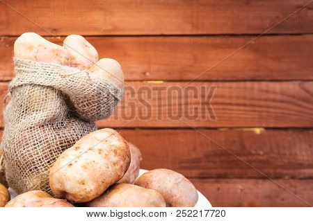 Patato Fresh  On A Beautiful Background. Red Wooden