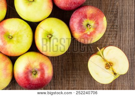 Lot Of Whole One Slice Of Fresh Red Apple James Grieve Variety Flatlay On Brown Wood