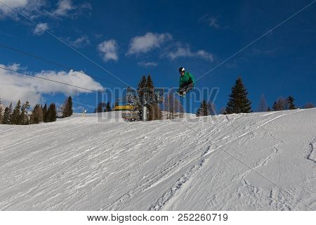 Skier In Action: Ski Jumping In The Mountain Snowpark
