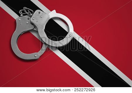 Trinidad And Tobago Flag  And Police Handcuffs. The Concept Of Crime And Offenses In The Country