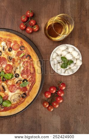 An Overhead Photo Of A Pepperoni Pizza With A Glass Of White Wine, Cherry Tomatoes And Mozzarellini 