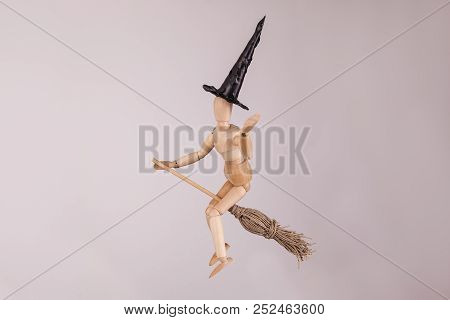 Jointed Manikin Dummy Figure Waving Dressed As A Halloween Witch Riding A Witches Broom On White Bac