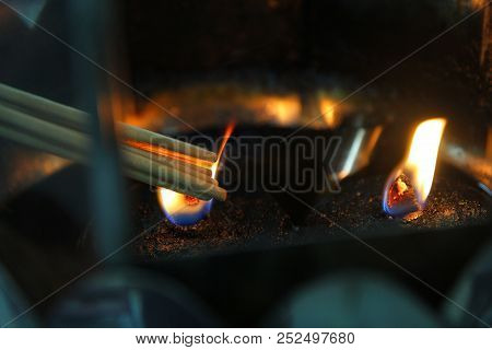 Buddhists Make Merit, Placing The Lit Incense With Lamp Frame For Worship Buddha. Selective Focus.