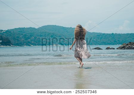 Handsome Girl On The Beach Background. Portrait Of A Woman In White Clothes On The Sea