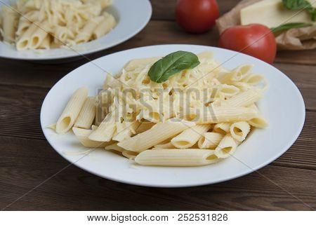 Cooked Penne Pasta With Butter And Cheese, Isolated In White Round Plate, Over Wooden Table, Decorat