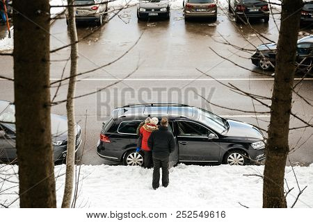 Mummelsee, Germany - Feb 18, 2018: View From Above Of Family Entering Volkswagen Passat Car On A Win