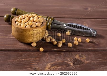 Lot Of Whole Raw Chickpeas Kabuli Variety With Wooden Bowl On Brown Wood