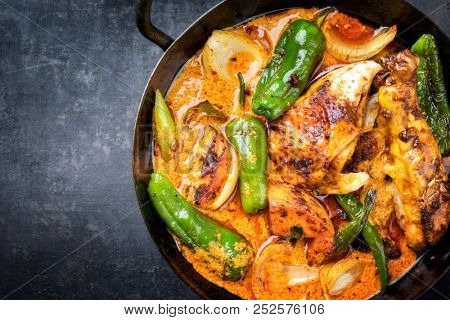 Traditional Thai kaeng massaman coconut chicken curry with jalapeno, poblano chili and sweet potatoes as closeup in a traditional bowl with copy space left