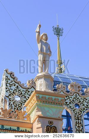 Moscow, Russia - August 01, 2018: Figure Of Steelworker Against Blue Sky On A Roof Of Pavilion Kazak